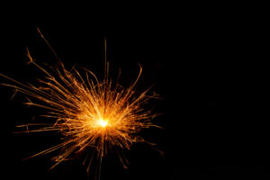 A lit sparkler showing bright sparks